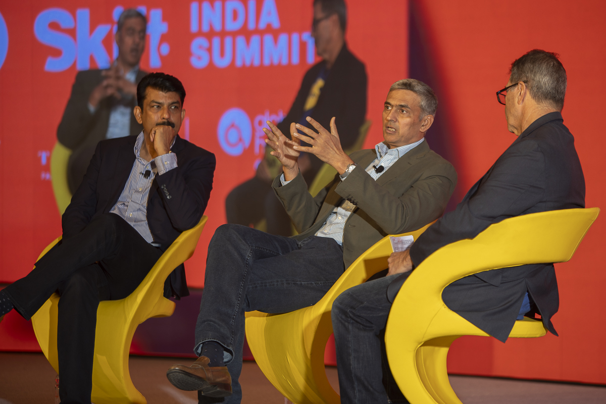 three men speaking on stage