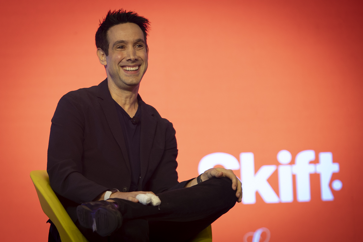 man sitting in a yellow chair on stage