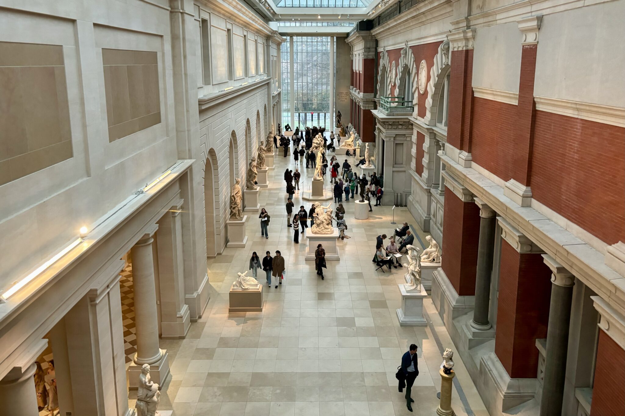 Aerial view of people milling among statues in a museum