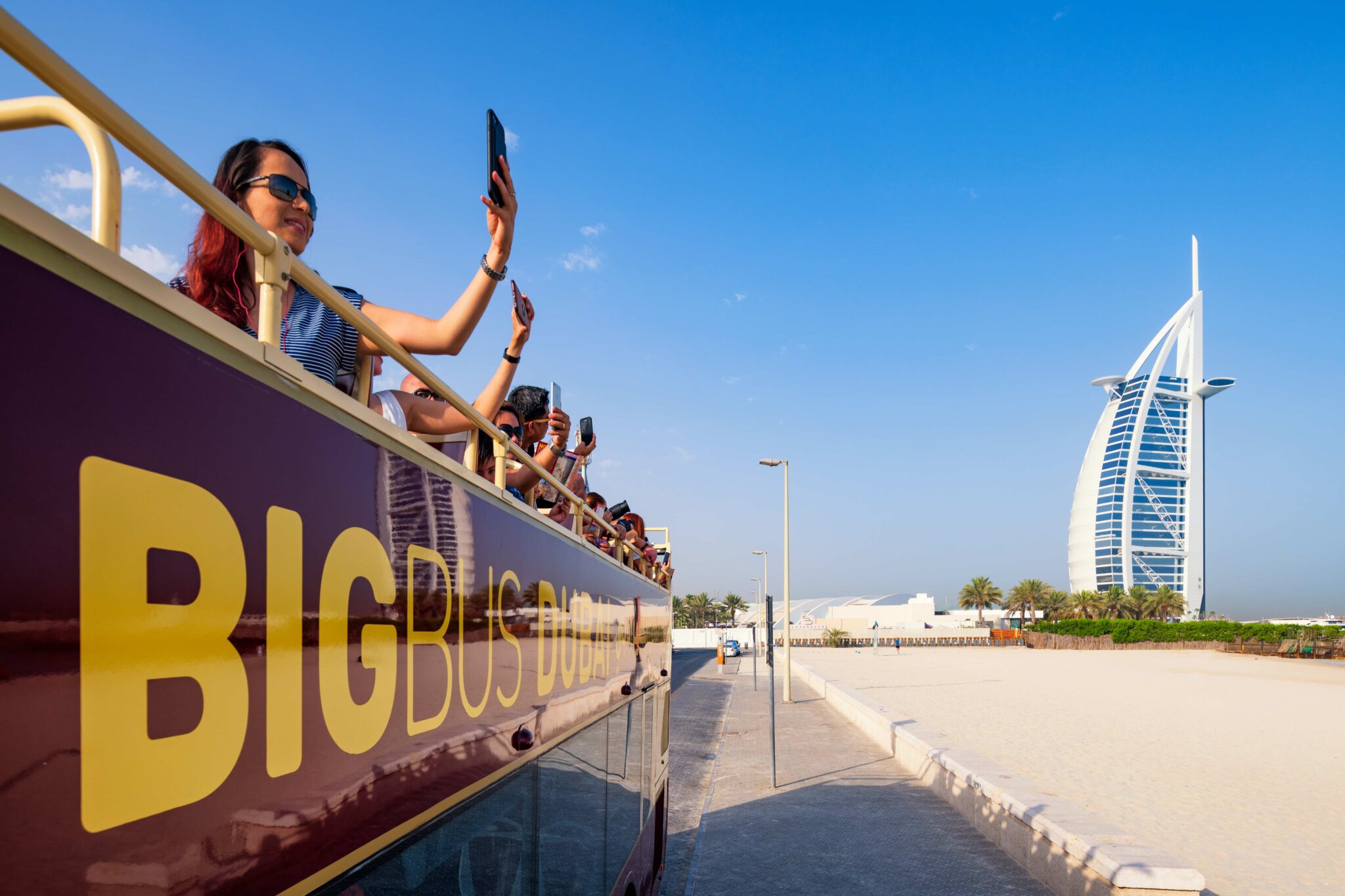 Tourists taking photos during a bus tour in Dubai