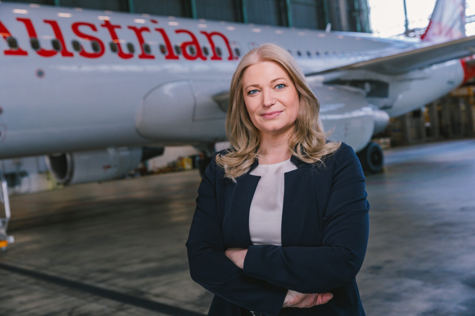 Annette Mann - Austrian Airlines CEO beside an airplane.