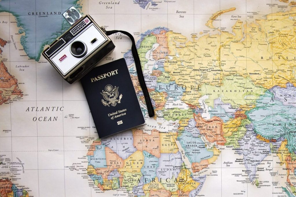 A world map with a passport and camera