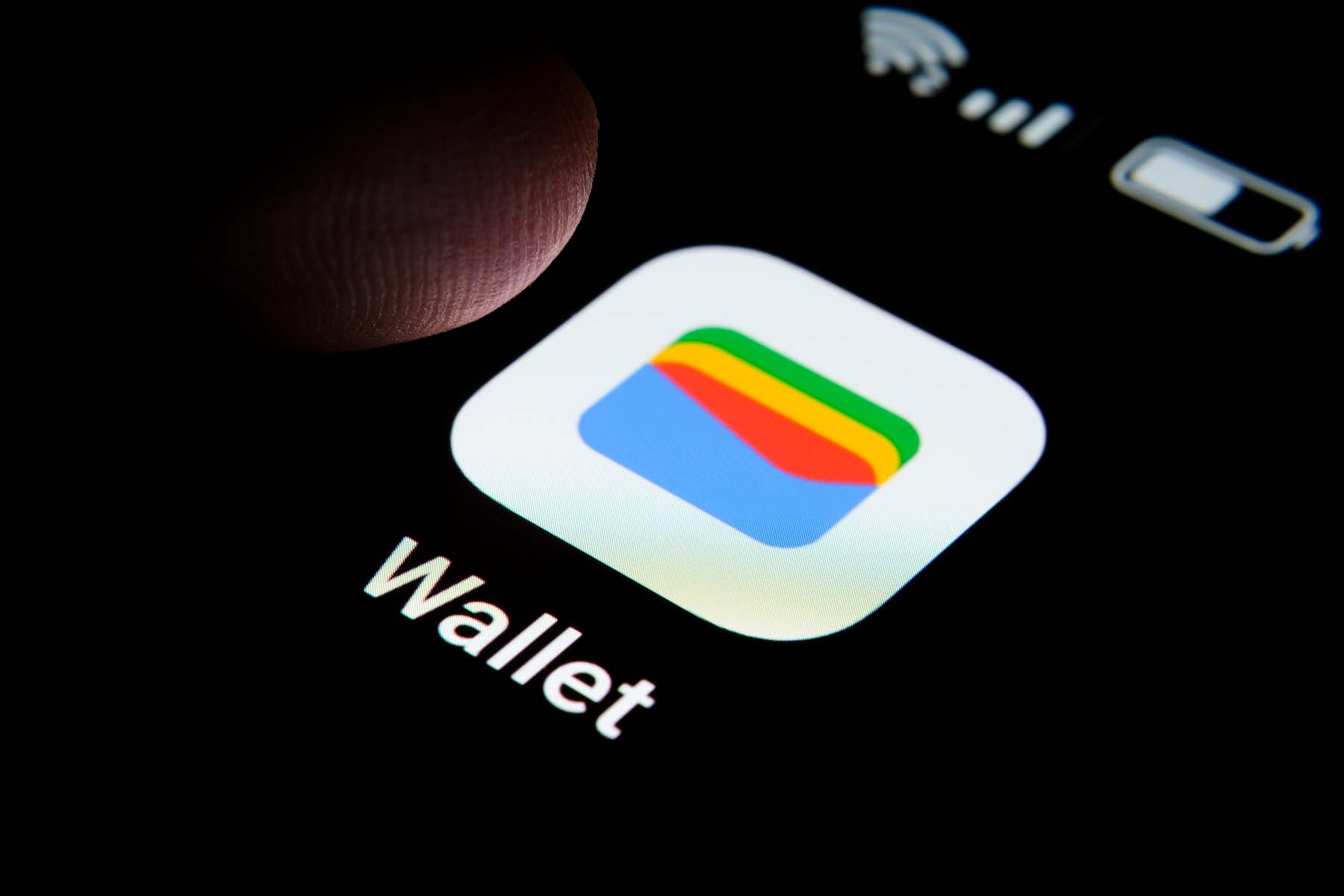 New Google Wallet app seen on the screen of smartphone and finger tip above it.