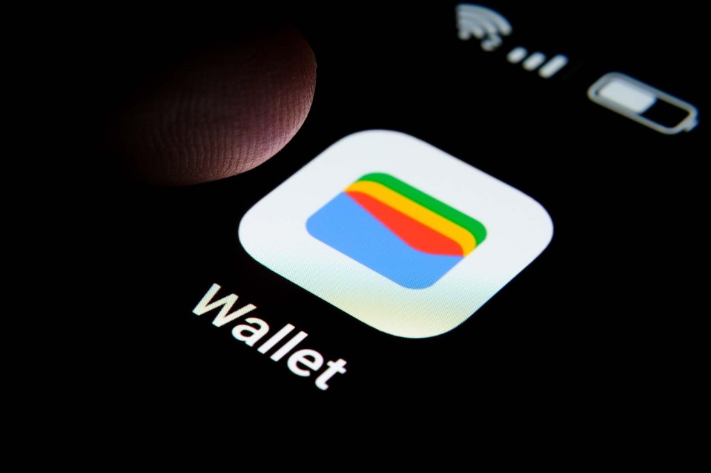 New Google Wallet app seen on the screen of smartphone and finger tip above it.