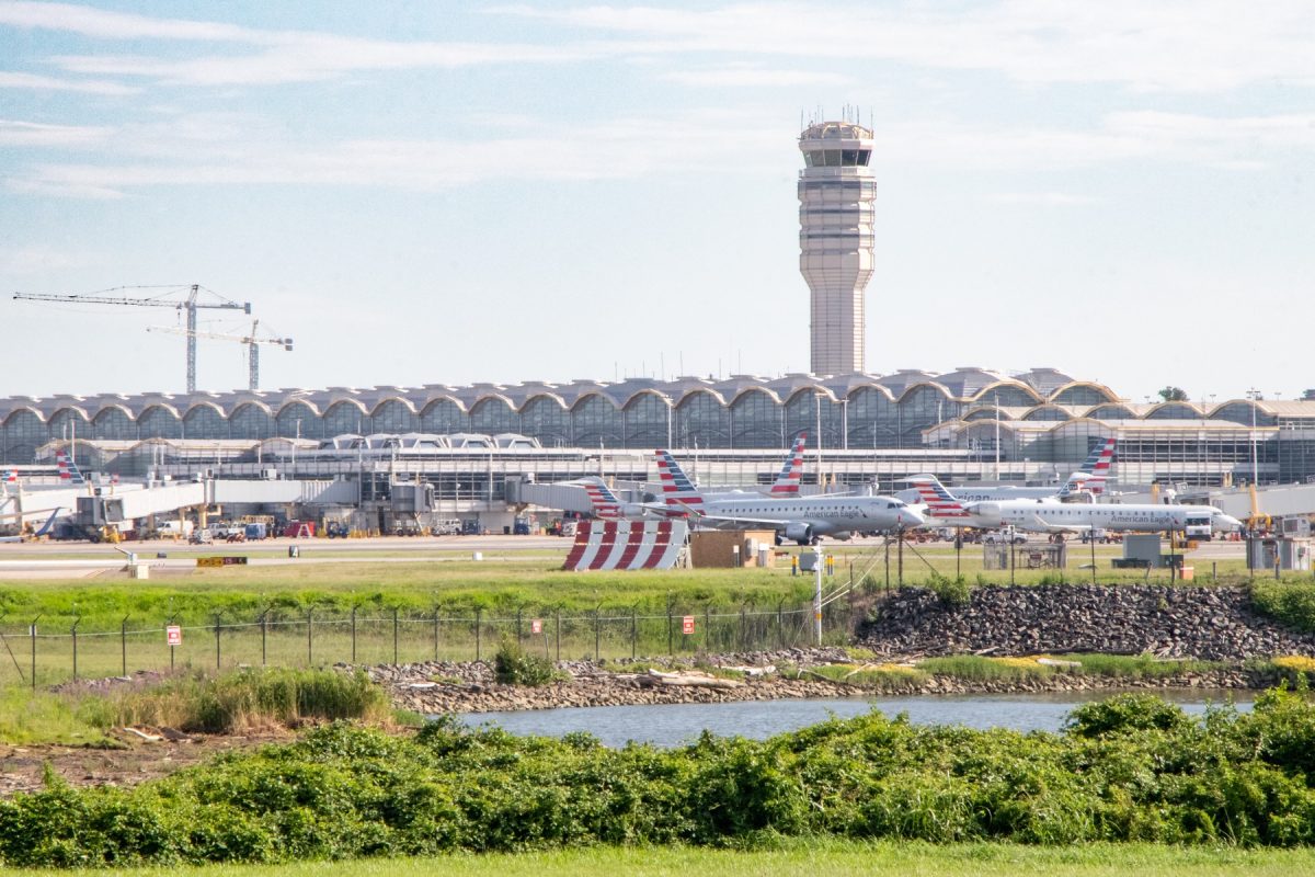 A crowded airport tarmac and air traffic control tower
