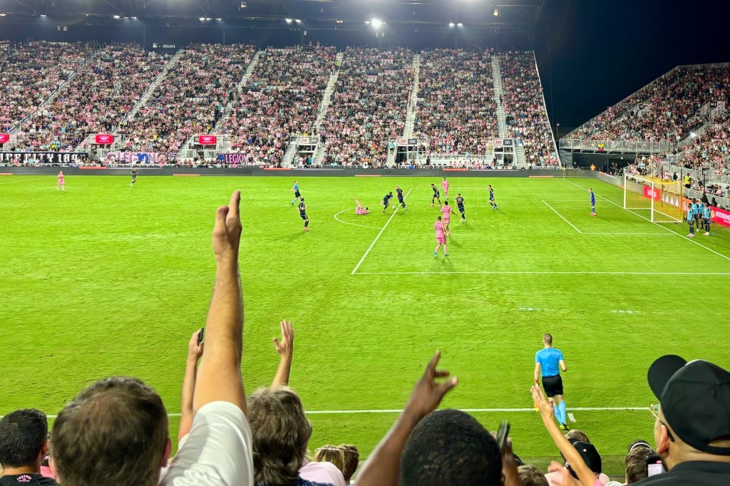 Fans reacting to a foul on a football pitch.