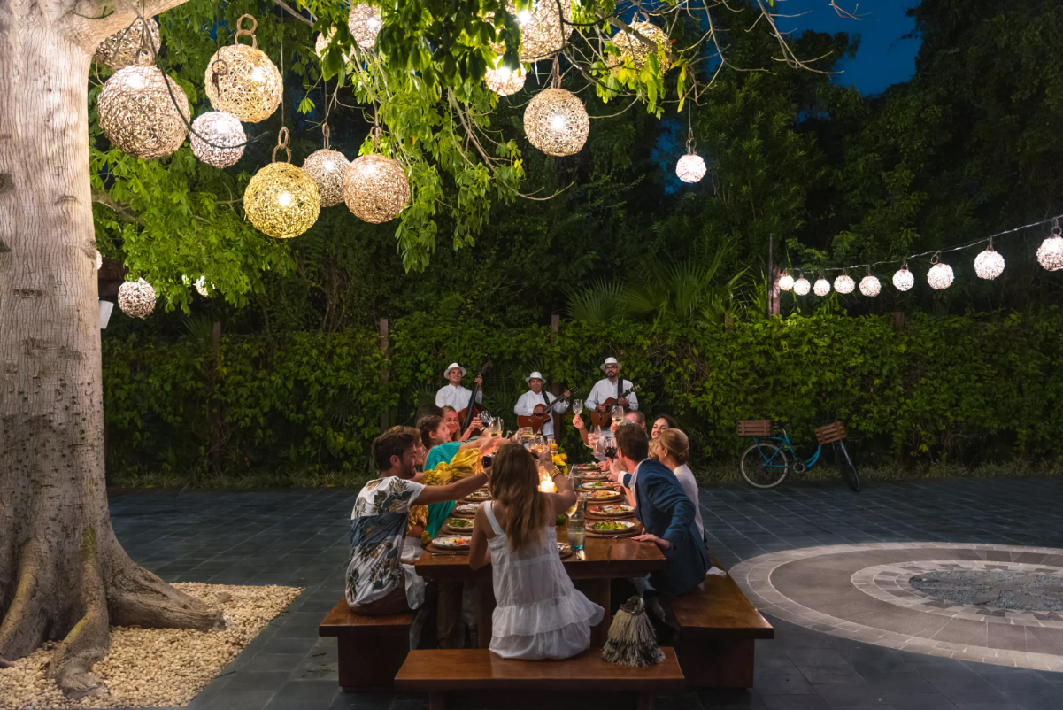 people eating at a long table outdoors at a luxury hotel