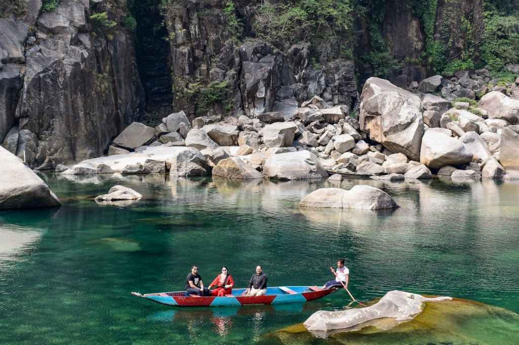 Tourists riding a boat in Dawki, Meghalaya.