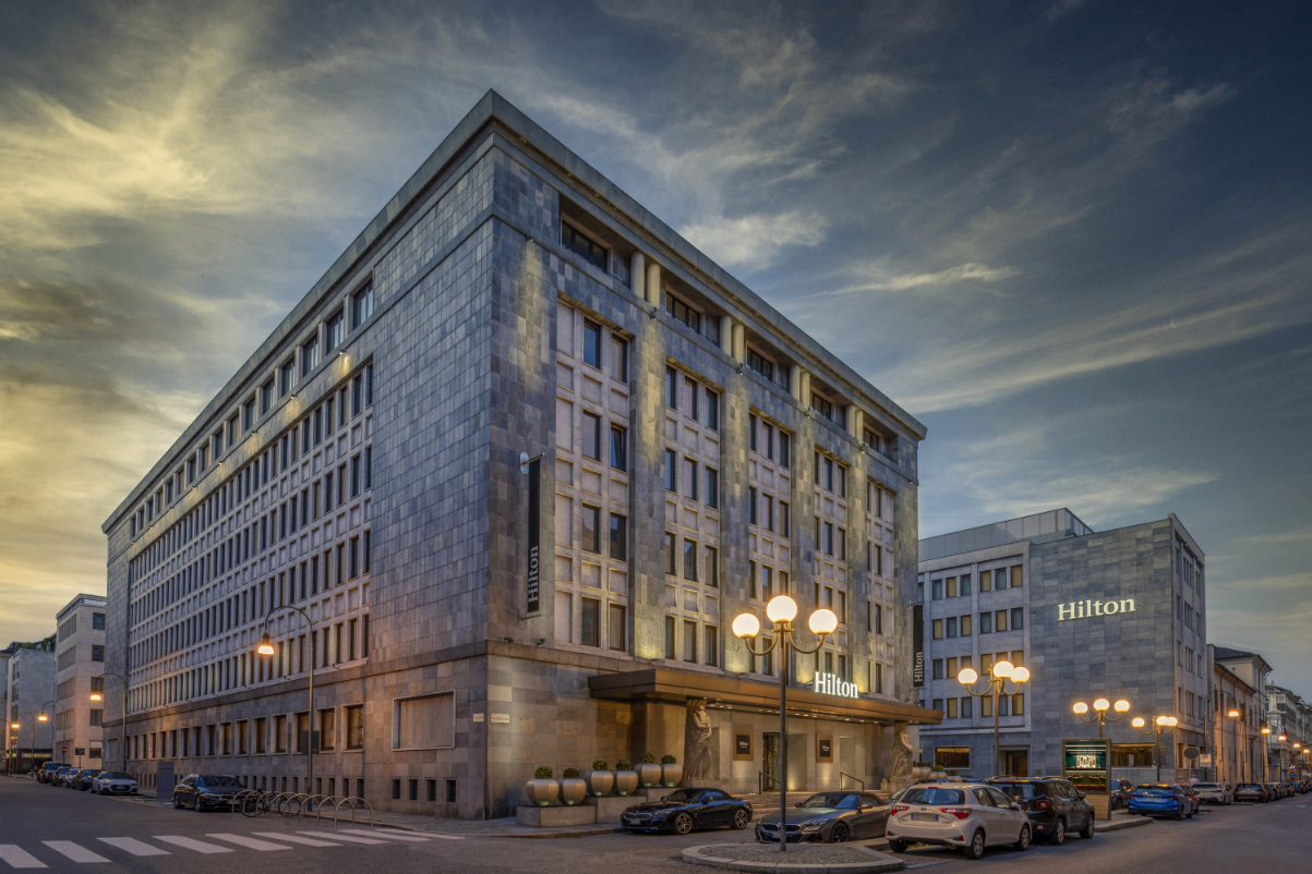 Exterior view of the new Hilton Turin Centre, seen at dusk with its austere edifice.