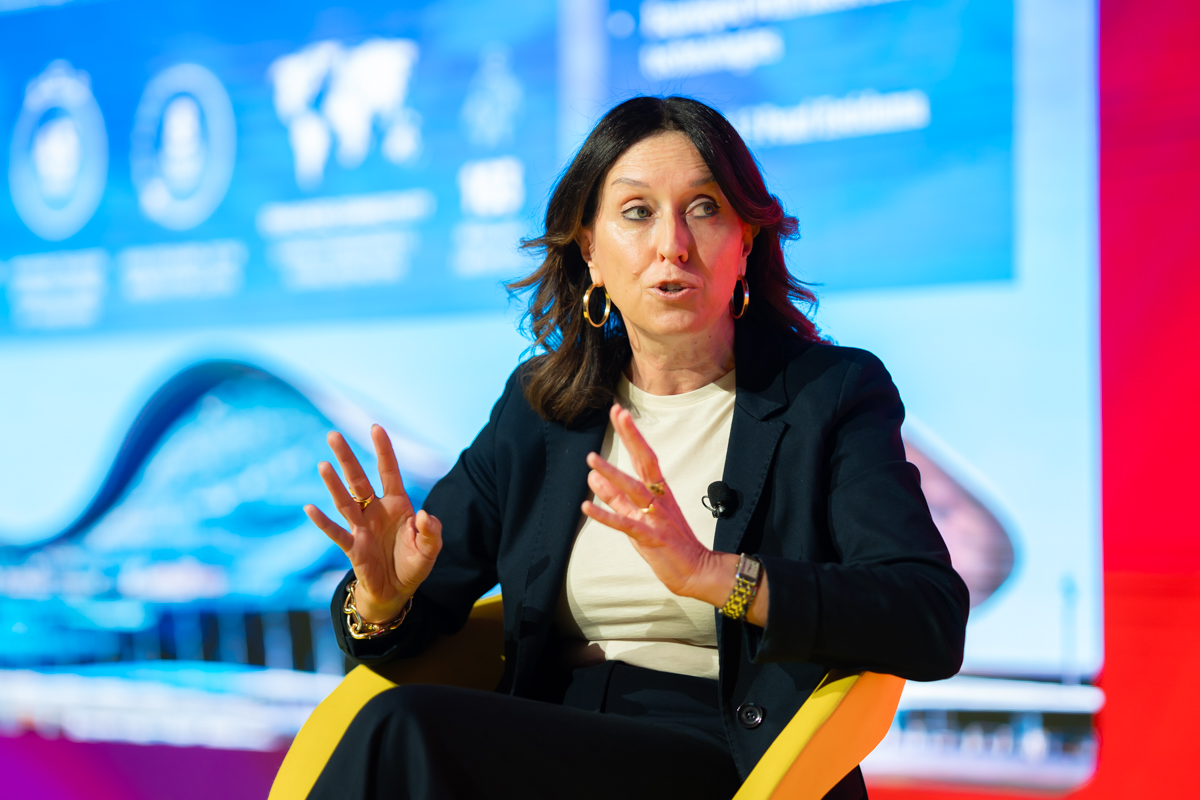 a woman speaking and gesturing on stage