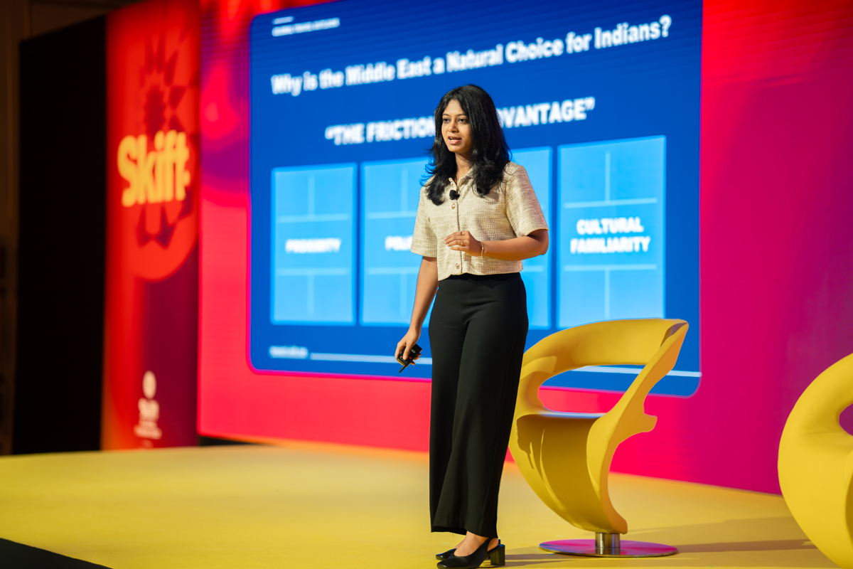 a woman speaking and gesturing on stage