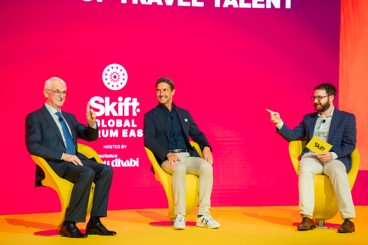 Three men in conversation on stage
