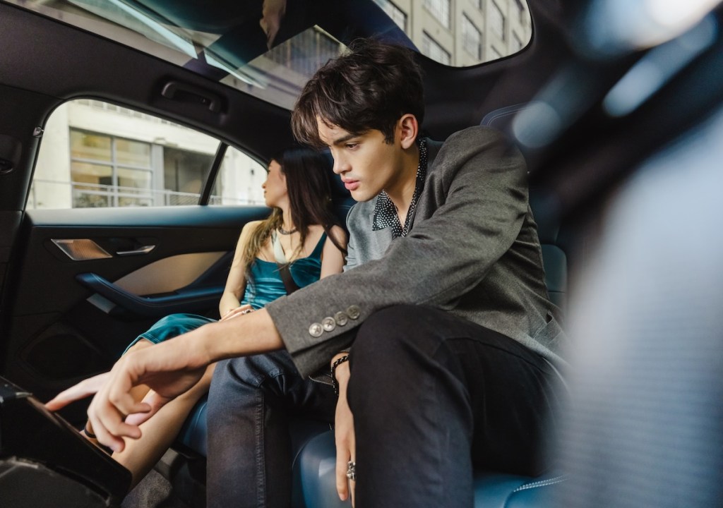 A man and a woman in a Waymo self-driving car.