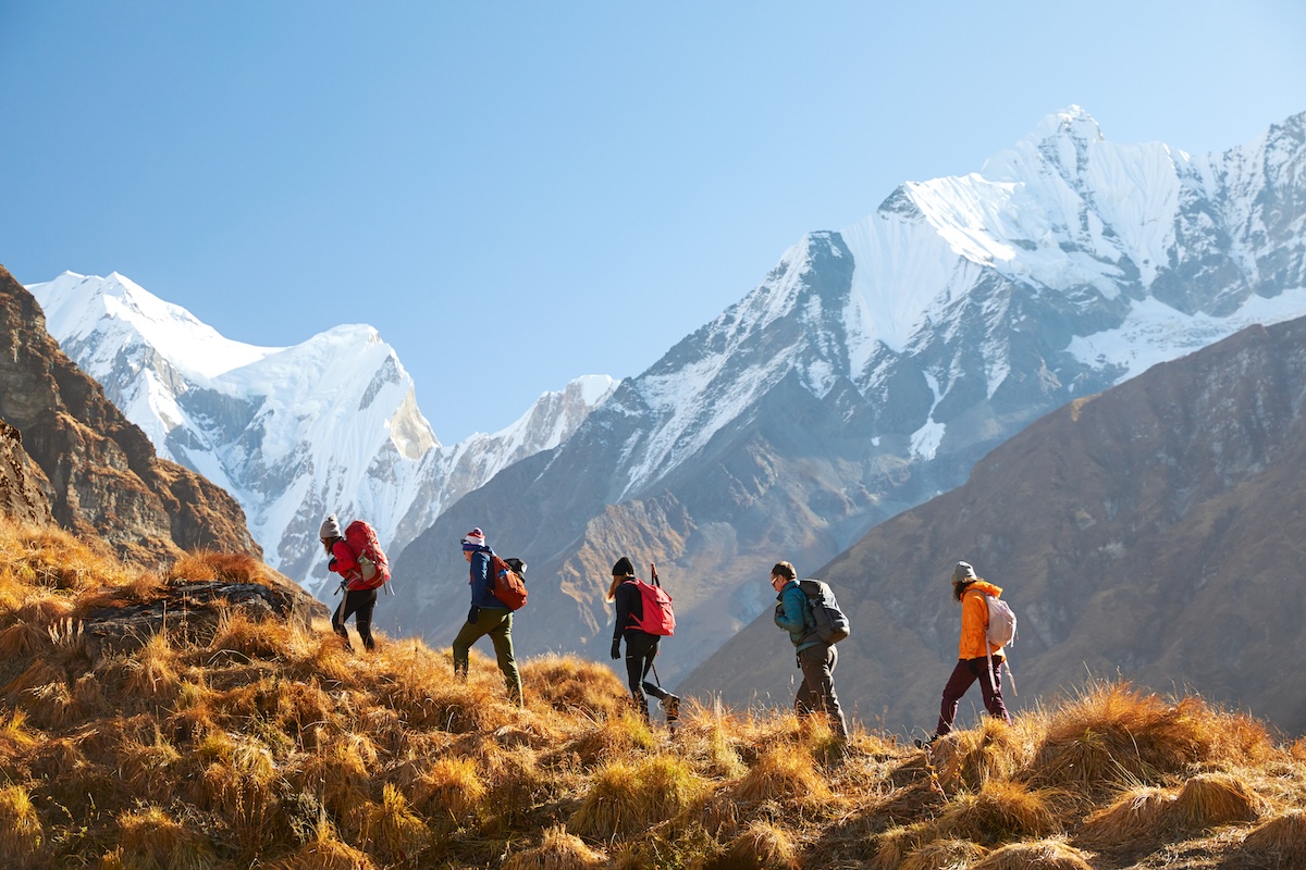 Five members of an Intrepid Travel trip trekking a mountain in Nepal.