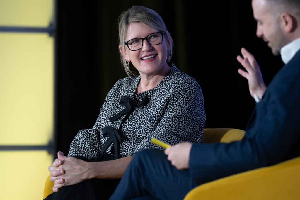 a woman executive of an airline talking onstage at a conference