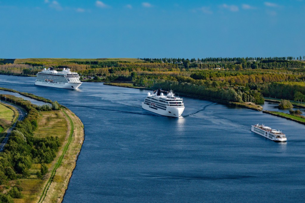 An image of three Viking cruise ships: one very big ocean vessel, next to a mid-size expedition cruiser, next to a small river cruising boat.
