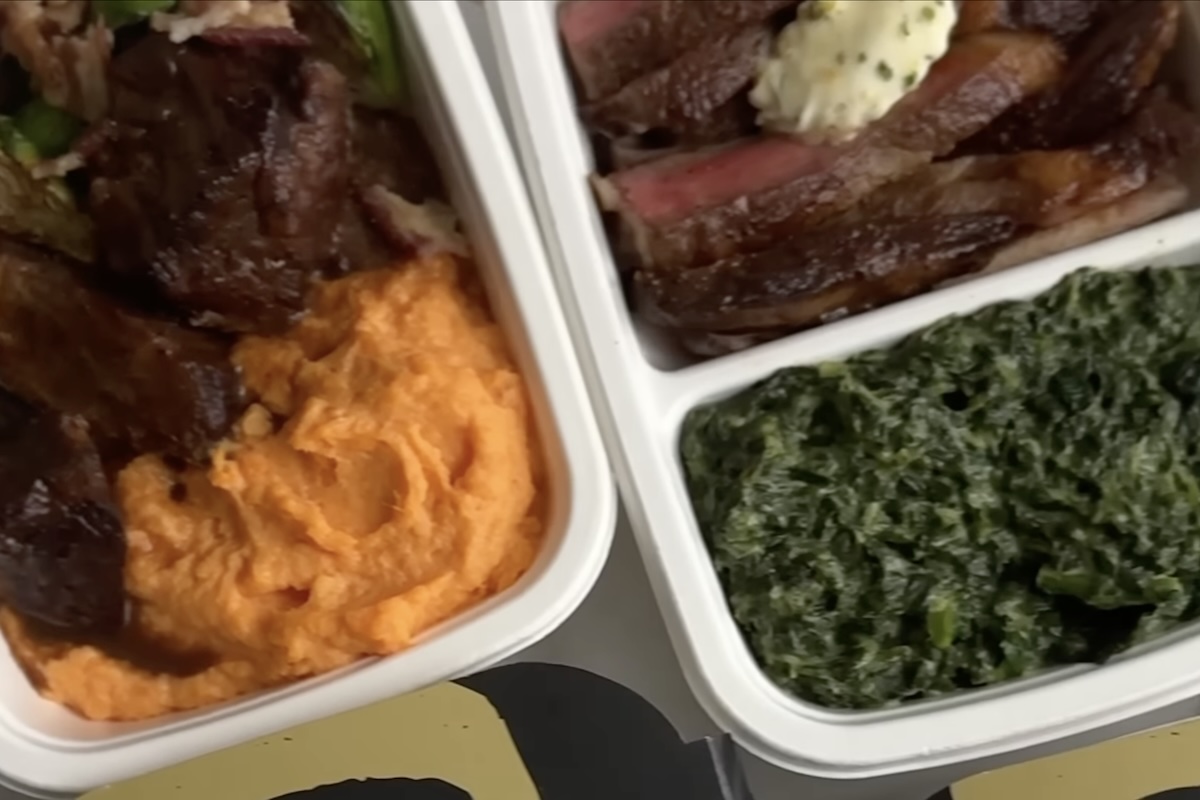Prepared meals in white containers.