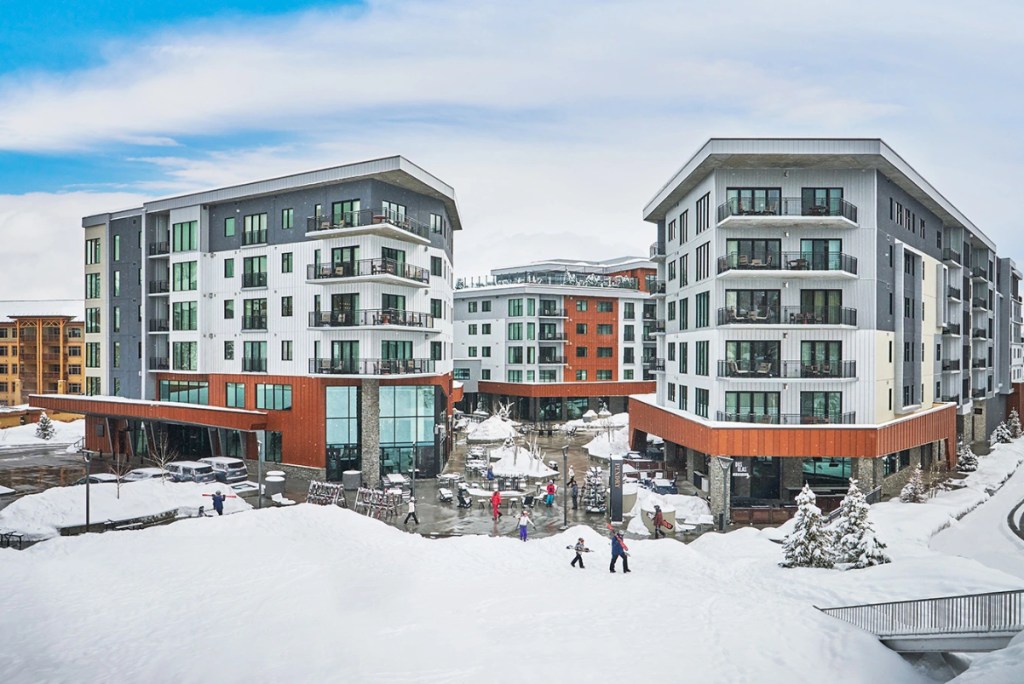 View of a ski-in, ski-out resort with a modern aesthetic on a sunny day with lots of snow on the ground in Park City, Utah.