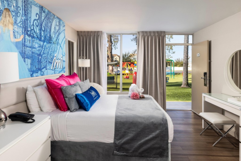 a hotel room aimed at families with young children, with a vibrant green lawn with toys outside the window
