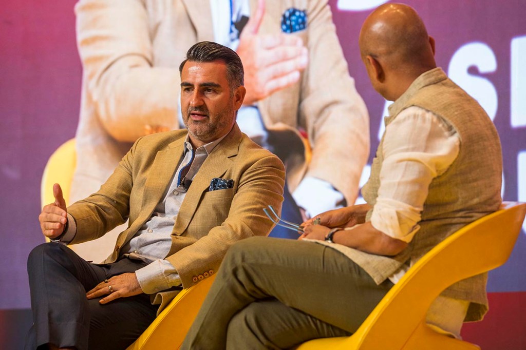 two men seated on a stage