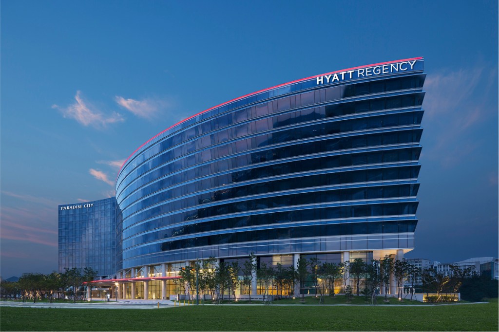 Image of a hotel exterior on a blue sky day showing the Hyatt Regency in Incheon, Korea.