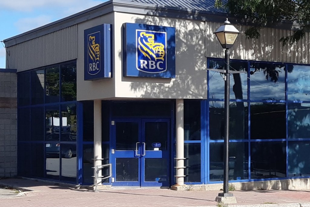 Exterior shot of a bank with a tree on one side in front.