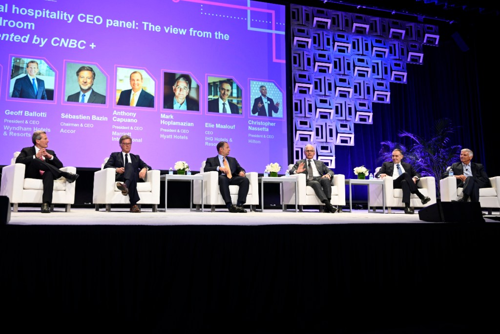 Thank you. A panel of major hotel CEOs sits on stage at a conference in New York in June 2025, all wearing suits.